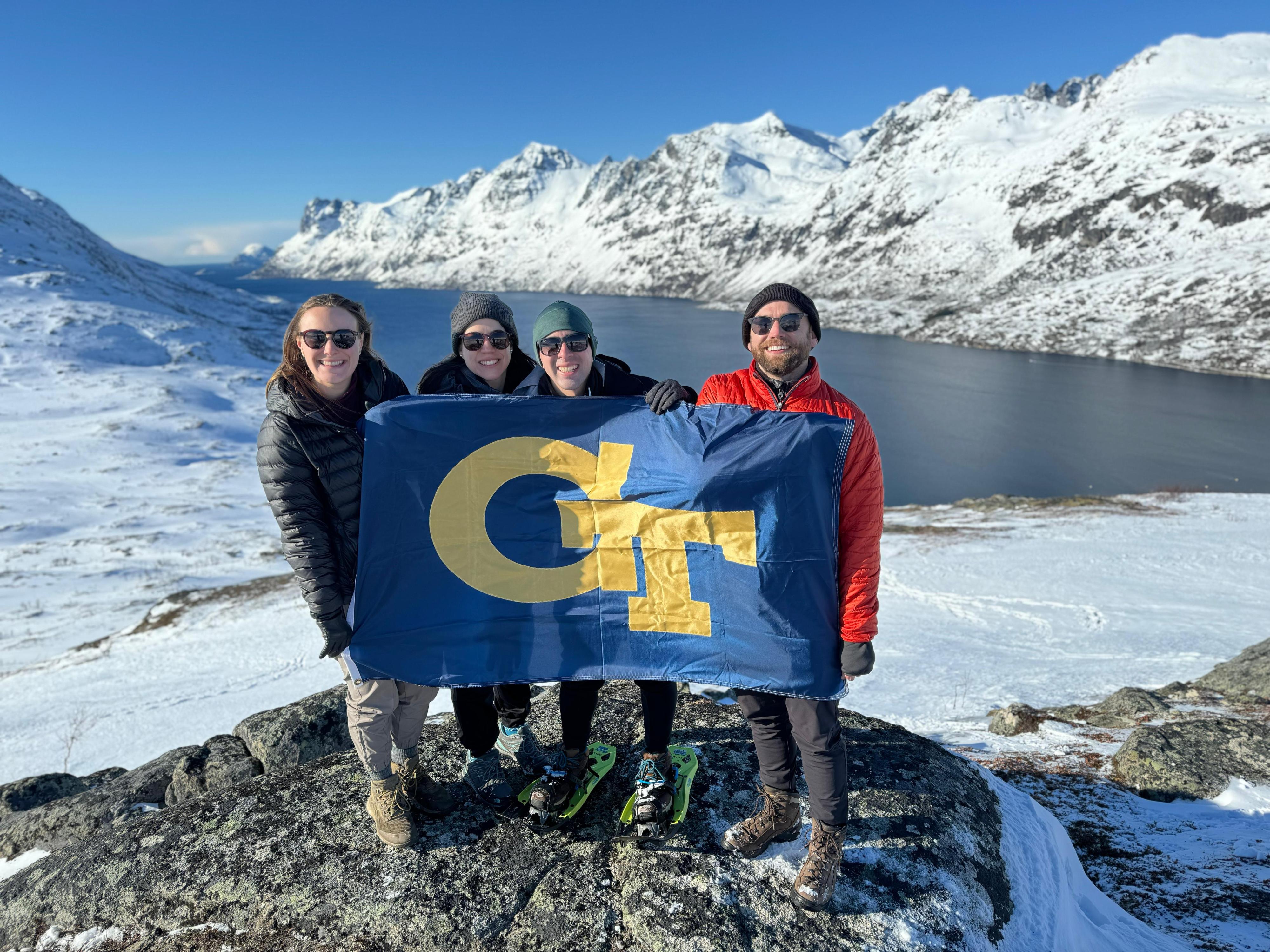 Students holding a GT flag in a mountain landscape