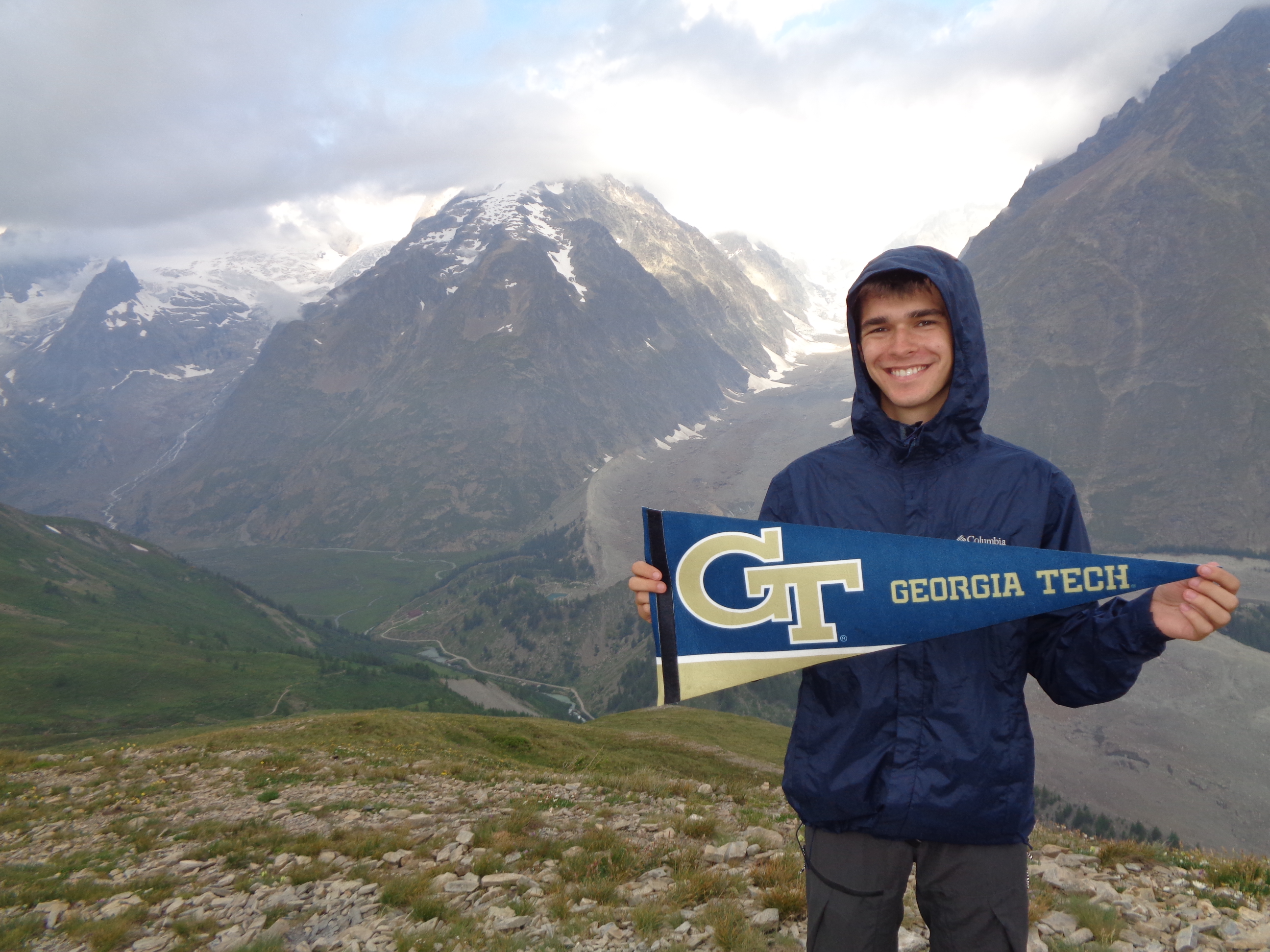 Student in the mountains with GT pennant. 